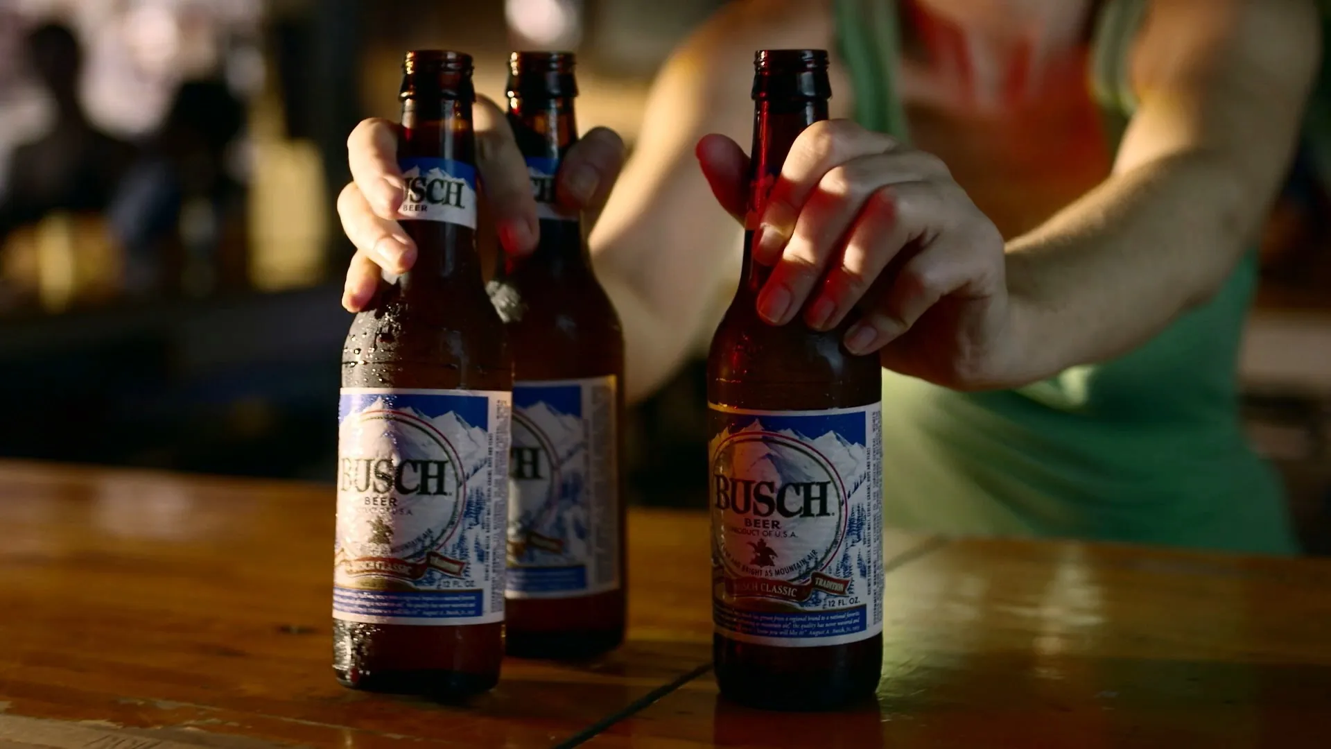 Hands on three Busch bottles at the bar, from the Busch Beer commercial
